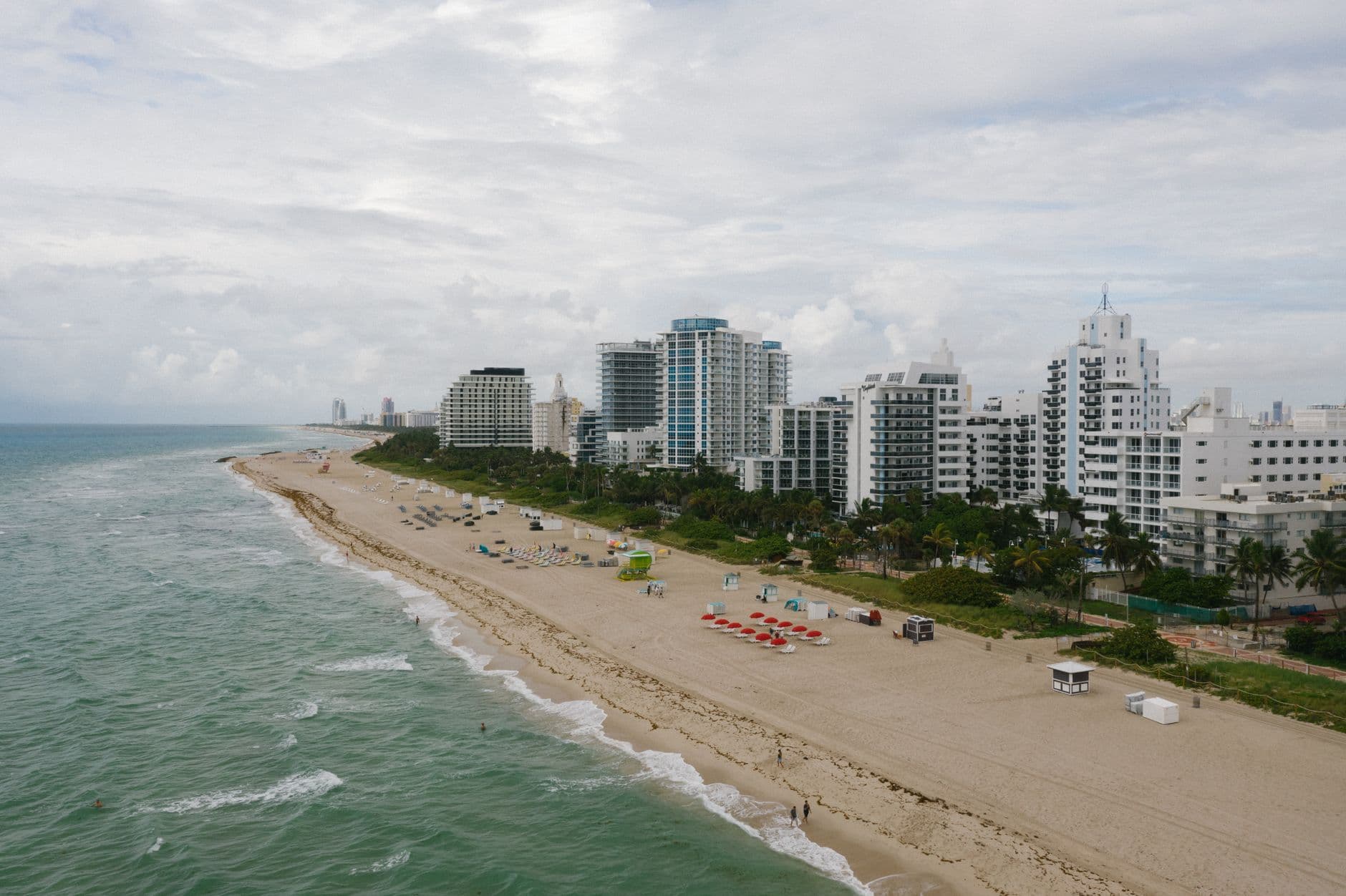 Aerial view of a South Florida beach and beachfront hotels under a cloudy sky ahead of a rainy weekend.