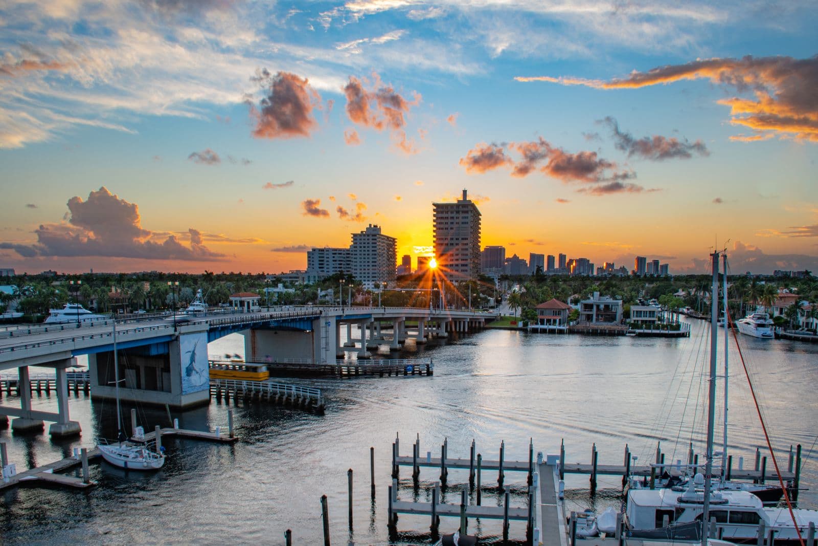 Sunrise over the Las Olas Bridge and marina in Fort Lauderdale, with boats docked along the Intracoastal and the downtown skyline behind, ahead of the final weekend of the Fort Lauderdale International Boat Show.